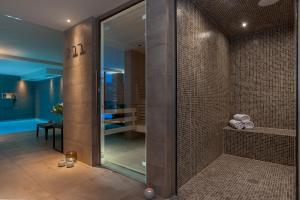 La salle de bains est pourvue d'une douche avec une porte en verre. dans l'établissement Annapurna by Alpine Residences, aux Gets