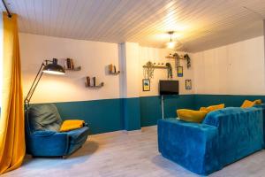 Levroux的住宿－Le petit cocon，客厅配有2把蓝色椅子和电视