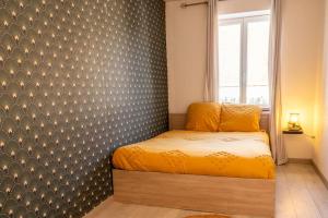 ein Schlafzimmer mit einem Bett in einem Zimmer mit einer Wand in der Unterkunft Le petit cocon in Levroux