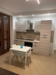 una cucina con tavolo e tavolo e sedie bianchi di casa manuel a Gallarate