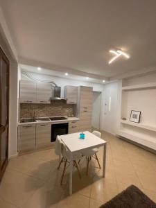 una cucina con tavolo bianco e tavolo e sedie bianchi di casa manuel a Gallarate Altre 15 foto