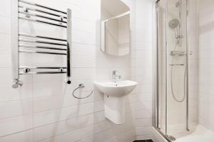 a white bathroom with a sink and a shower at Cosy studio flat (Finchley Rd) in London