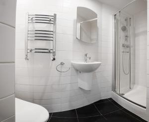 a white bathroom with a sink and a shower at Cosy studio flat (Finchley Rd) in London