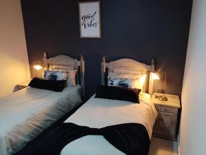 2 Betten in einem Schlafzimmer mit 2 Lampen auf einem Tisch in der Unterkunft Tshepang Apartments Secunda in Secunda