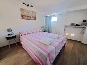 una camera con un letto con lenzuola a righe rosa e bianche di Alloggiamo a Modena