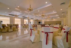 um salão de banquetes com mesas brancas e cadeiras com arcos vermelhos em Comfort Inn Karnal em Tirāwari
