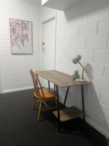 a table and a chair with a lamp and a desk at Apartment on Parker in Devonport