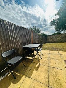 una mesa y sillas en un patio junto a una valla en Astor house Maidstone long stay, en Maidstone