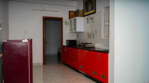 cocina con armarios rojos y encimera roja en LAGUNA Guesthouse, en Chennai