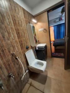a bathroom with a toilet and a sink and a mirror at Staeg Skyline View 3BHK - 1404 in Indore