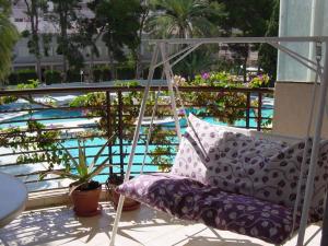 une balancelle avec des oreillers sur un balcon avec une piscine dans l'établissement Apar2amento maravillo2o Con vistas al mar, à Calp
