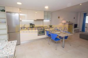- une cuisine avec une table et des chaises bleues dans la chambre dans l'établissement Apar2amento maravillo2o Con vistas al mar, à Calp