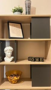 a shelf with a bowl and a home sign on it at Koukaki Cozy Studio Retreat 1' from metro in Athens
