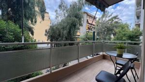 a balcony with a table and a view of trees at Koukaki Cozy Studio Retreat 1' from metro in Athens