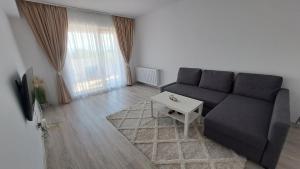 a living room with a couch and a table at Apartament Ramonte in Zărneşti