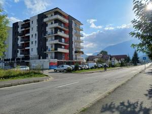 an empty street in front of a tall building at Apartament Ramonte in Zărneşti
