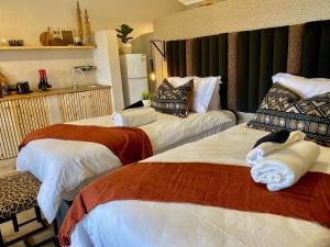 a hotel room with two beds with towels on them at Fever Tree Guesthouse in Hillcrest