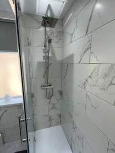baño con ducha y puerta de cristal en 3 Bedroom House Brighouse, en Brighouse