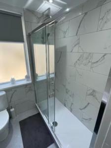 a bathroom with a glass shower and a toilet at 3 Bedroom House Brighouse in Brighouse