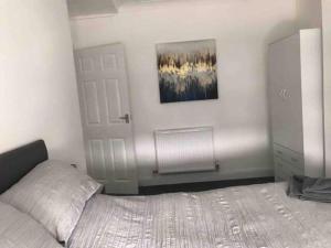 a bedroom with a bed and a white door at 3 Bedroom House Brighouse in Brighouse