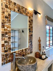 ein Badezimmer mit einem Steinwaschbecken und einem Spiegel in der Unterkunft Fever Tree Guesthouse in Hillcrest