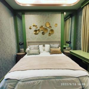 ein Schlafzimmer mit einem großen Bett mit grünen Wänden in der Unterkunft Apartment Embarcadero Bintaro Suites by Novie Mckenzie in Pondokaren