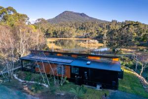 an aerial view of a house next to a lake at Quamby Bluff Lake House, Deloraine, Tasmania in Golden Valley