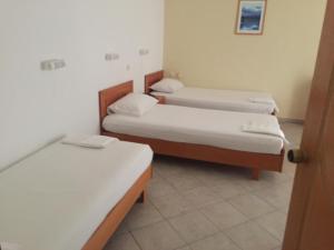 a room with three beds in a room at Iris Hotel in Nea Kalikratia