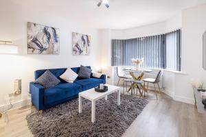 sala de estar con sofá azul y mesa en Spacious 2 Bed Home with FREE PARKING and Netflix, en Maidenhead