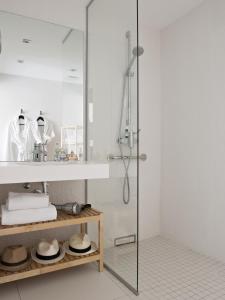 La salle de bains est pourvue d'une douche avec une porte en verre. dans l'établissement Hotel Rohan, Centre Cathédrale, à Strasbourg