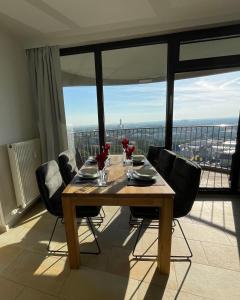 mesa de comedor con sillas y vistas a la ciudad en Augsburg Hotelturm, en Augsburg