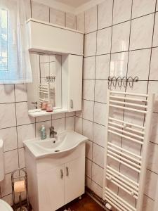 a white bathroom with a sink and a mirror at Studio Apartman Iovia place in Ludbreg