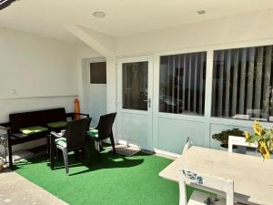 een woonkamer met een tafel en stoelen en een groen tapijt bij Studio Apartman Iovia place in Ludbreg
