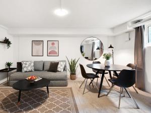 ein Wohnzimmer mit einem Sofa und einem Tisch in der Unterkunft Sanders Charm - Cozy One-Bedroom Apartment with Shared Garden in Kopenhagen