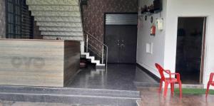 a room with two red chairs and a staircase at OYO Flagship Tirupati Lawn And Hotel in Lucknow