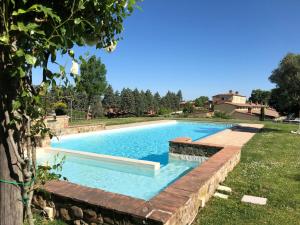 a swimming pool in a yard with a retaining wall at Luxury Resort with swimming pool in the Tuscan countryside, Villas on the ground floor with private outdoor area with panoramic view in Osteria Delle Noci