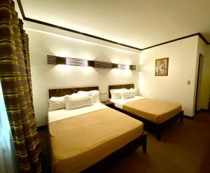 Lingayen的住宿－艾爾普艾爾托瑪麗納海灘度假勝地及度假俱樂部，一间酒店客房内设有两张床的房间