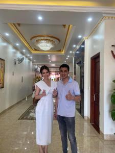 um homem e uma mulher posando para uma foto num edifício em Minh Cường Hotel em Mộc Châu