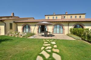 uma casa com um relvado em frente em Luxury Resort with swimming pool in the Tuscan countryside, Villas on the ground floor with private outdoor area with panoramic view em Osteria Delle Noci