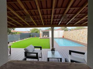 un patio con mesa, sillas y piscina en Casa da Ti Bemvinda, 