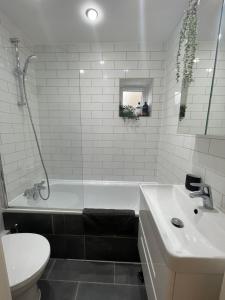 a bathroom with a tub and a sink and a toilet at Notting Hill Studio Room in London