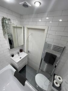 bagno bianco con lavandino e servizi igienici di Notting Hill Studio Room a Londra