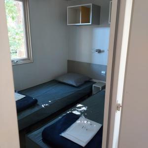 a small room with two beds and a window at Camping Onlycamp Les Pins in Nançay +12 photos