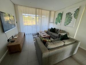 a living room with a couch and a flat screen tv at Pebble Beach Sibaya No.122 in Sibaya