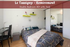 a bedroom with a bed and a table and a desk at Le Tassigny - Hyper-Centre Balneo in Remiremont