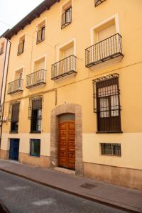 un edificio amarillo con una puerta de madera en una calle en Casa Ángeles en Teruel