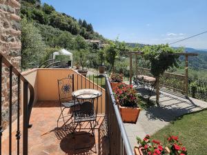 balcone con sedie, tavolo e fiori di Shaleo, Casa indipendente con piscina privata, Marliana a Marliana