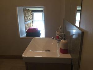 La salle de bains est pourvue d'un lavabo avec miroir et d'une fenêtre. dans l'établissement Cherry Blossom Cottage, à Gorre 10 autres photos