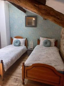 une chambre avec deux lits et un miroir au mur dans l'établissement Cherry Blossom Cottage, à Gorre