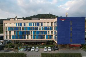 an aerial view of a building with cars parked in a parking lot at Hampton by Hilton Samsun in Samsun